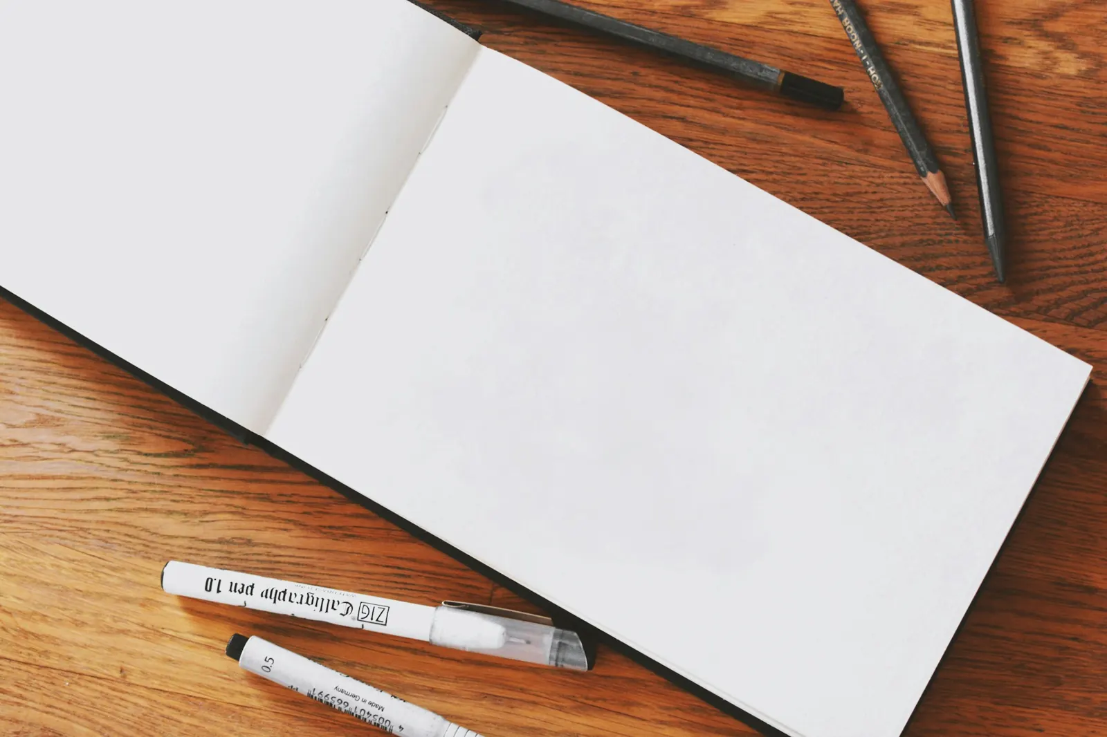 Cuaderno de bocetos abierto en blanco con rotuladores calibrados